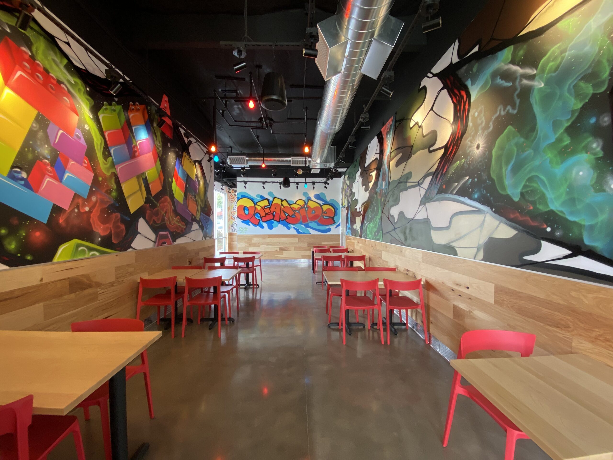 Bright interior photo of Dave's Hot Chicken in OceaNside, CA that has the word Oceanside in graffiti